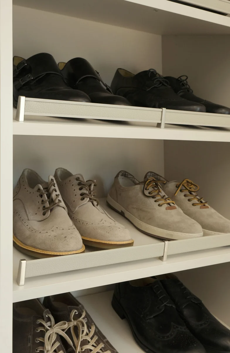 Shelves of shoes held neatly in place by upholstered shoe fences